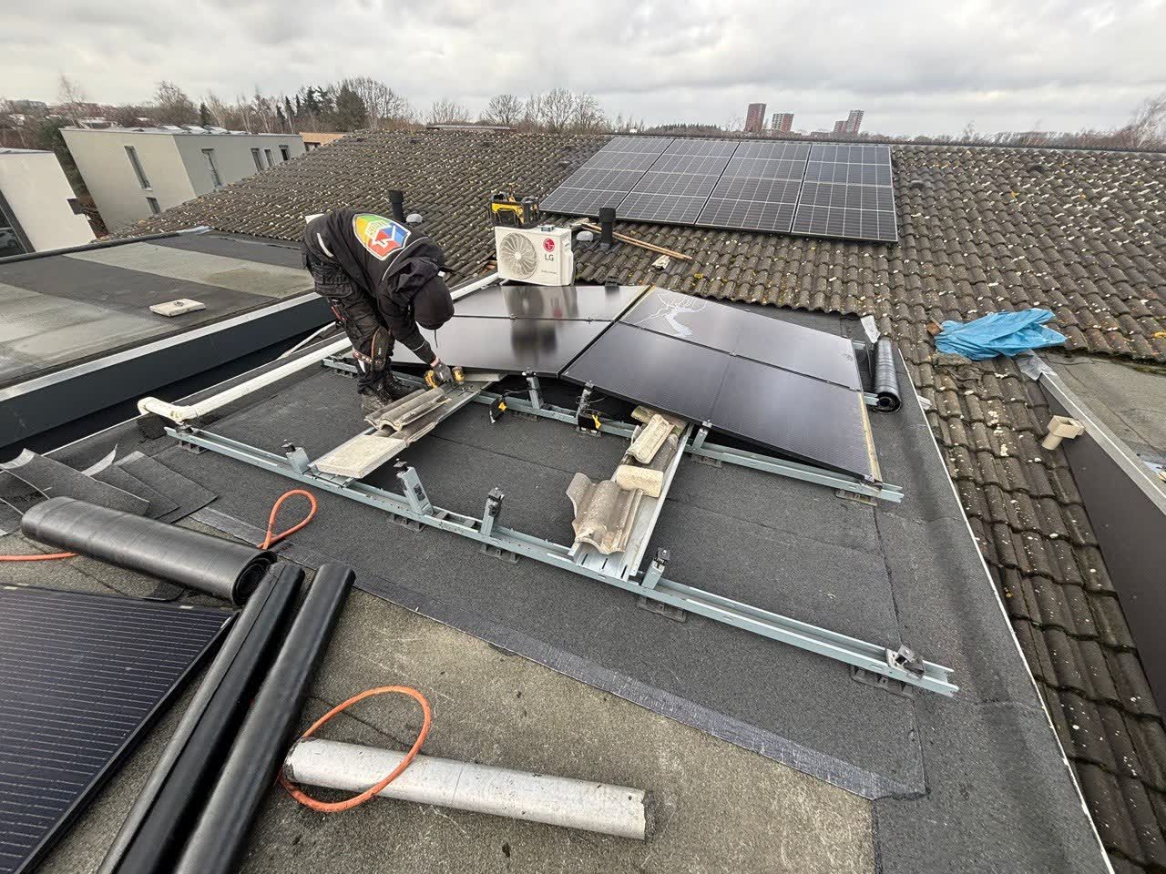 Vakman van TBGS aan het werk op een plat dak met zonnepanelen