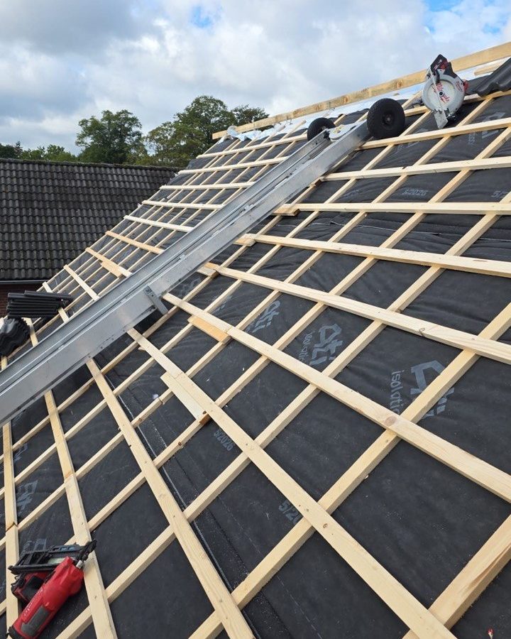 Nieuwe tengels en panlatten over de isolatiefolie, met een ladderlift op het dak