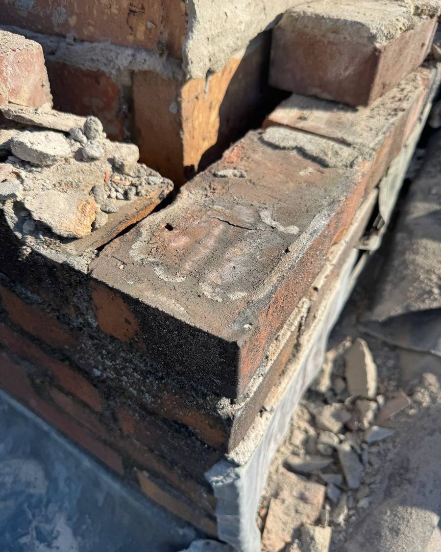 Detail van schoorsteenmetselwerk met langdurige vochtindringing en vorstschade in de steen